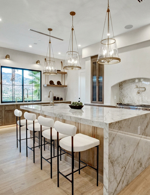 Modern Kitchen With Marble Island and Elegant Lighting Fixtures